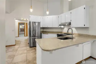 Kitchen with breakfast nook, heated floors, stainless steel appliances, vaulted ceilings, and quartz counters
