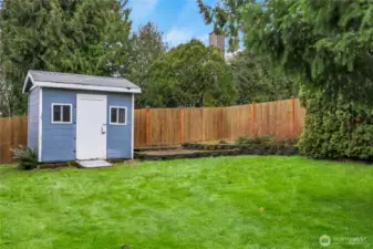 Level, fully fenced backyard with shed