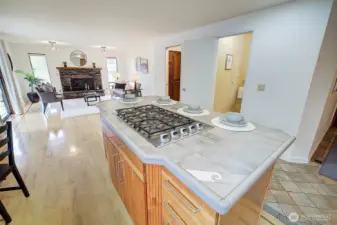 A large island features a gas cooktop and offers bar stool seating for casual meals or entertaining.