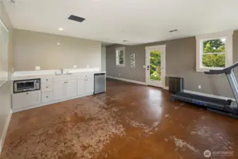 Lower-level kitchenette with sink, cabinetry, and beverage fridge—ideal for guests or extended stays.