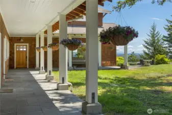 Welcoming covered porch with classic columns and hanging planters, offering a charming approach to the home.
