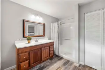 Primary bath has a two bench walk-in shower and ample storage.