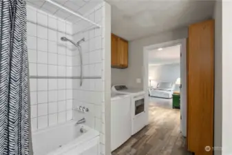 Laundry in bathroom offers additional storage cabinets