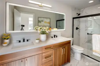 Glass Paned Shower In Primary Bathroom Featuring New Lighting And Full Sized Mirror  Virtually staged