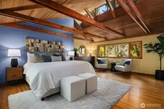 Primary suite feels like a treehouse hideaway—vaulted ceilings, hardwoods, ensuite bath, and a private deck with outdoor shower.