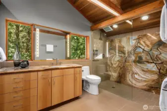 Enjoy the luxury of radiant in-floor heat in the primary bath, complete with a walk-in shower accented by a striking solid stone wall