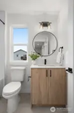 Modern, clean lines meet curated textures—this secondary bath is all about the details, from the round mirror to the matte black hardware.
