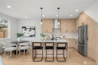 Say hello to your statement kitchen. With quartz counters, warm flat-panel cabinetry, designer lighting, and an island built for brunching, this kitchen is a chef’s kiss.