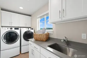 The laundry room features a sink, folding counter and custom stroage cabinetry.