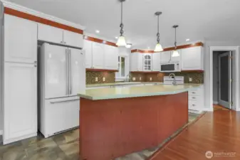 Bar/island with pendant lights is truly convenient and appealing.  Matching appliance suite with French door refrigerator.