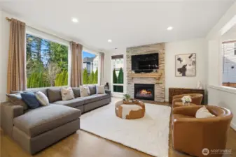 Great room with large windows and gas fireplace highlights both natural light and a cozy ambiance.