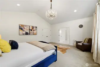 Primary bedroom featuring double doors to hallway and primary bathroom.