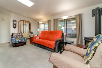 Open concept living room with skylights; bright, airy, and ideal for entertaining, with a seamless transition between living and dining areas, accentuated by natural light.