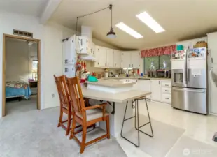 Kitchen with an eating bar and skylights. New Refrigerator, Stove, and Sink. Adjacent to the Primary Bedroom.