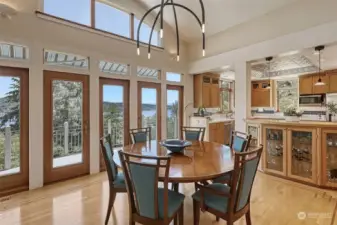 The Dining Room is open to the kitchen for easy gathering and entertaining. Note the custom etched windows above to further the views and light streaming in.