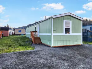 This home has fresh exterior paint that enhances its curb appeal, complemented by brand-new porches the new skirting adds a polished touch, while the newly installed gravel walking path provides convenience and functionality