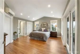 Primary bedroom with vaulted ceilings, walk in closet and deck access.