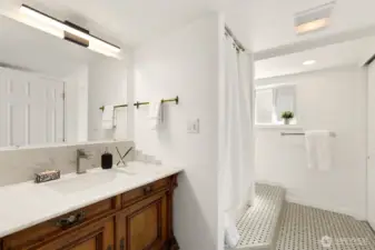 Three-quarter bath in lower level.  Antique vanity installed with new sink, Carrera marble counter tops and plenty of closet/storage space.