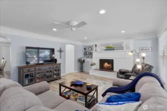 Spacious, light-filled living room * Cozy fireplace with custom mantle * Elegant built-in shelving