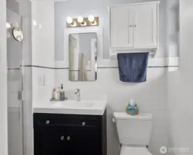 Crisp white tile with subtle navy accent * Modern vanity with sleek fixtures
