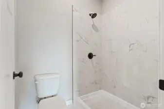 Primary bathroom shower and toilet room.