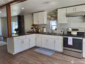 N porcelain backsplash and freshly painted kitchen cabinets, granite countertops