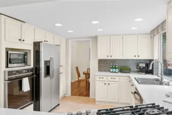 Updated kitchen with stainless steel appliances, quartz countertops, and a new stove/range.