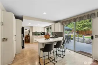 Kitchen area with breakfast bar makes keeping connected easier. With sliding door to the back deck.
