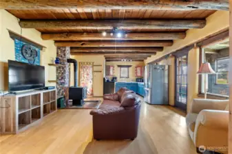 Open floor plan with kitchen, living room, and dining room situated between wings of the house.