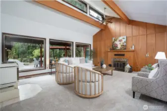 Expansive living room with vaulted ceilings, and natural light.