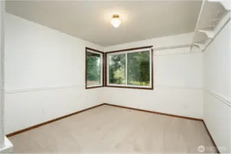 Bright and comfortable bedroom featuring soft carpeting, large windows with peaceful outdoor views, and a functional layout. Includes convenient closet space and plenty of room to personalize.
