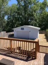 There are stairs from the deck down to the back yard, hot tub, patio and garage. Here you can also see the RV parking next to the garage. There is additional space behind the garage for your use. The access to that space is a 90 degree turn at the fence line. it's a perfect place to build a shed, greenhouse or???