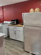 Another view of the lower level kitchen. There is space to add additional cabinets if you need more. The cabinet in this photo is movable. It is not attached to the wall or the floor. It will remain in the house for the next owner.