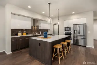 Bold and contemporary, the dual cabinetry; warm wood lowers and shiny white upper and stainless fridge and ovens frames.