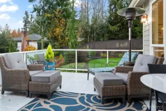 Outdoor entertaining deck with glass railing, heater, and privacy backdrop—perfect for year-round enjoyment in Gig Harbor.