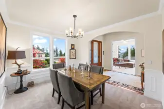 Formal dining room with classic millwork, abundant natural light, views of the meticulously landscaped front gardens and filtered Sound views through the evergreens.