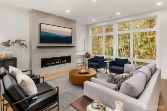Great room highlighted by gathering space with 10 foot window walls overlooking protected greenbelt, linear contemporary fireplace with designer tile surround and steel mantel
