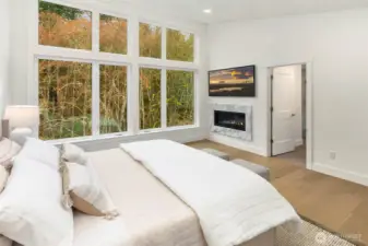 Stunning and Serene primary suite with window walls and contemporary fireplace with tile surround