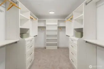 Spacious primary closet with custom designed and built solid shelving and drawers. Solid closet shelving throughout the home