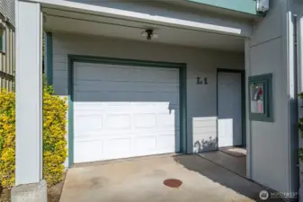 Garage door leads into long garage with space for two cars.