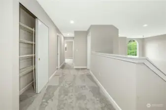 Upper Level Hallway provides spacious storage closest and a view down into the Formal Living & Dining Rooms.