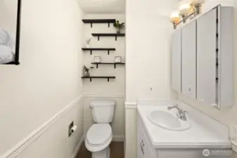 Bathroom makes great use of space with mirrored storage and lots of shelving.