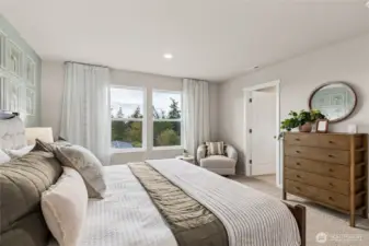 Huge primary bedroom with space for a King size mattress, nightstands, dressers, televisions, and accent furniture. Photo is representational. Actual home is under construction. Colors, materials, and features may vary. See site agent for details.