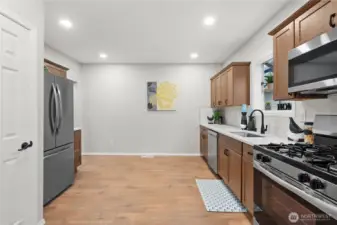 View entering into the Kitchen w/New Cabinets, Stainless Steel Appliances w/Gas Range and Over the Range Microwave. French Door Fridge w/Lower Freezer. In the Closet you'll find the New Gas Water Heater and Pantry Space.