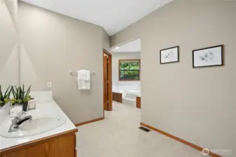 Primary bath has double vanity, soaking tub and tile shower