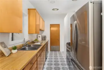 The galley kitchen features stainless steel appliances and a gas stove