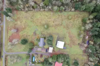 Aerial view highlighting over 5 acres of land with outbuildings and a shared easement with neighbors on the south side.