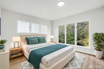 Virtually staged 2nd bedroom main floor bedroom is very nice. The large windows provide lots of natural light, and peaceful woods view.