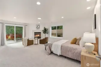 Spacious main-floor primary suite with sitting area and cozy fireplace.