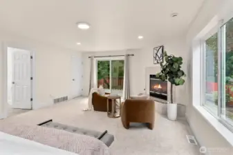 Spacious main-floor primary suite with sitting area and cozy fireplace.